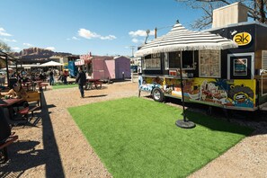 A food truck with a menu board and a tented structure in the background. - Luxury Casita R5 - 2 Master Suites and 2.5 Bathrooms (Moab)