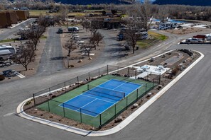 An aerial view of a sports complex with a tennis court, parking areas, and surrounding buildings. - 3bd/3ba Luxury Vacation Home M24 - 3bd/3ba Luxury Vacation Home M24 (Moab)