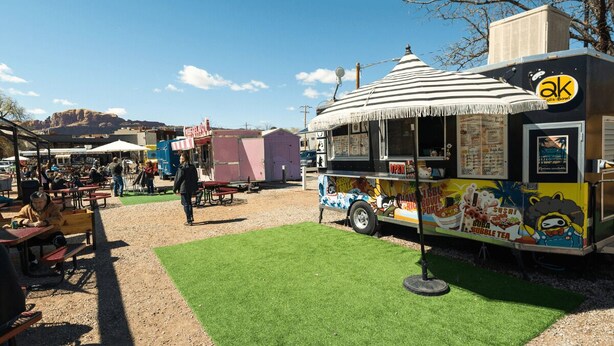 A food truck with a menu board and a thatched roof, located in an outdoor market area with tables and chairs. - Luxury Vacation Home 4-BED M20 - 4 master suites and 4.5 bathrooms (Moab)
