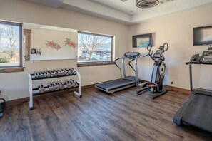 A home gym with a treadmill, elliptical, and dumbbells. - Luxury Vacation Home 4-BED M20 - 4 master suites and 4.5 bathrooms (Moab)