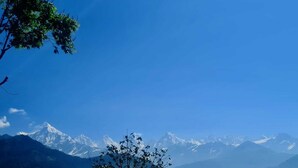 A mountain range with snow-capped peaks under a clear blue sky. - We are not a commercial hotel... we are your home (Munsyari)
