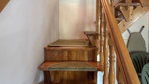 A wooden staircase with a wooden chair and a small table.