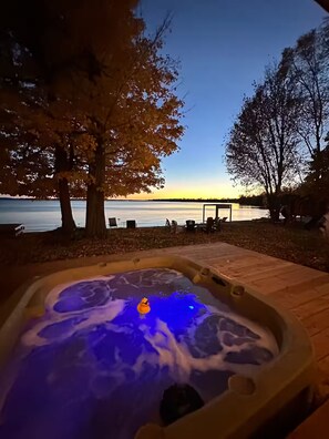 A hot tub with a view of a lake at dusk. - Bees Beach House: Luxury 5BR Sturgeon Lakefront w/ Private Sandy Beach & Sauna (Kawartha Lakes)