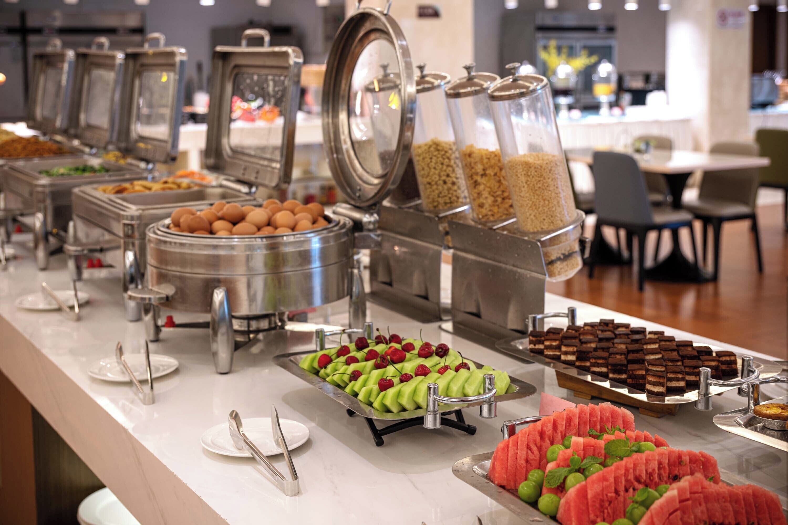 A buffet with various food items and utensils.