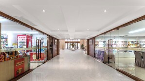 A corridor with glass storefronts on both sides, a central walkway, and a ceiling with recessed lighting. - Lu'an Garden Hotel Shanghai (Shanghai)