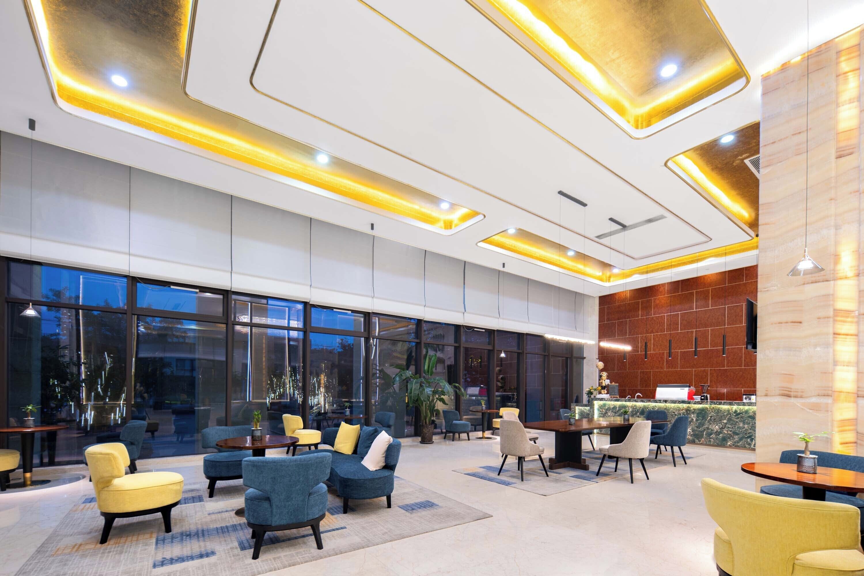 Een ruime lobby met moderne zitplaatsen, een receptiebalie en grote ramen.