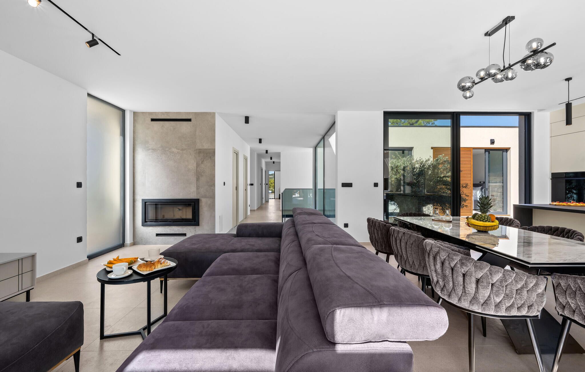 Una cocina moderna con comedor, un largo banco y vistas al exterior.