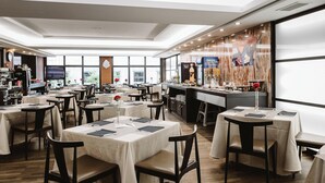 A restaurant with multiple tables, chairs, and a bar area.