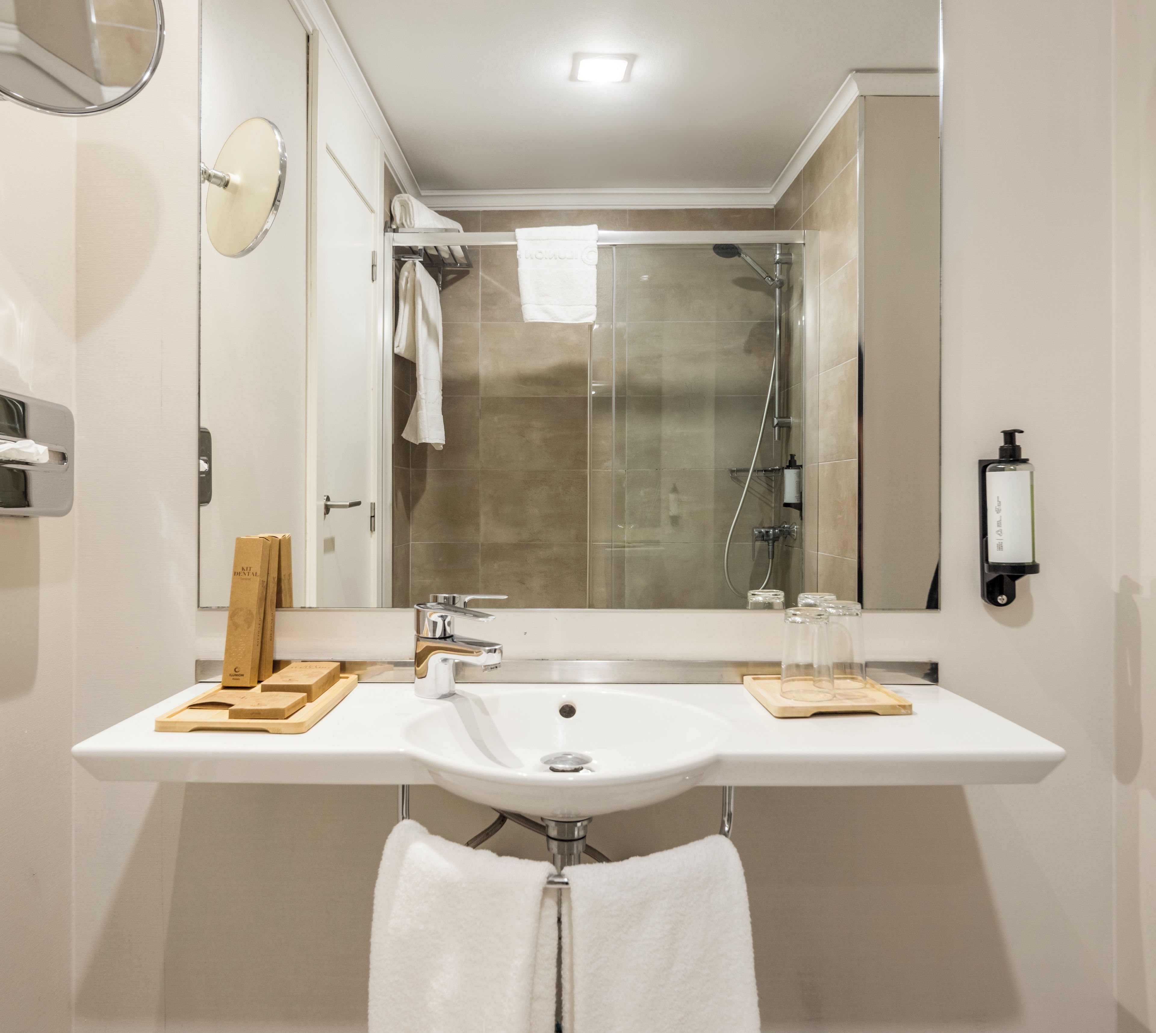 Un baño moderno con lavamanos doble, cabina de ducha de vidrio y un espejo.