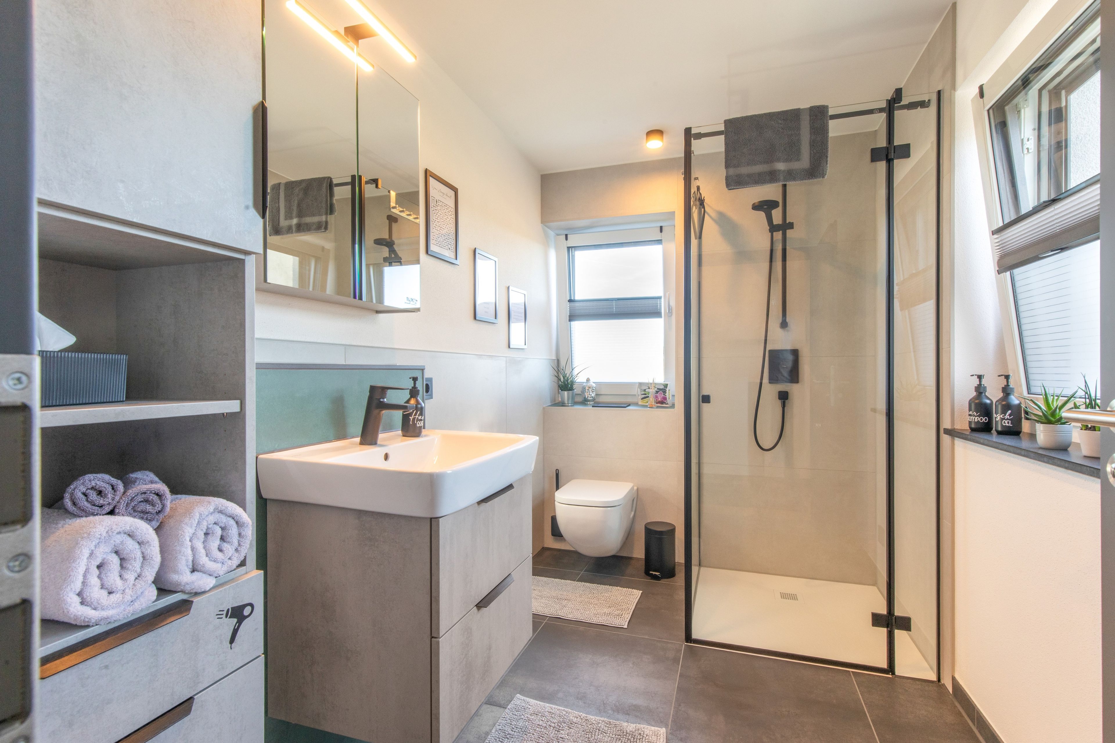 Ein modernes Badezimmer mit Dusche, Toilette und Waschbecken.
