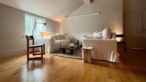 A spacious living room with a high ceiling, a large window, and a door. - Grand 2BR Penthouse Projector Hyde Park (London)