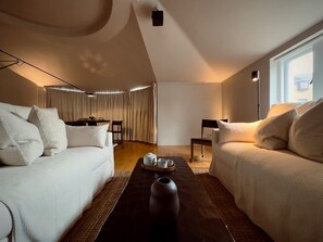 A modern living room with a sofa, a coffee table, and a lamp. - Grand 2BR Penthouse 100 Cinema Hyde Park (London)