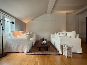 A modern living room with two white sofas, a coffee table, and a floor lamp. - Grand 2BR Penthouse 100 Cinema Hyde Park (London)