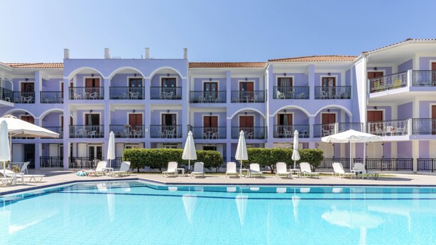 Un hotel con piscina, varios balcones y zonas de estar al aire libre.