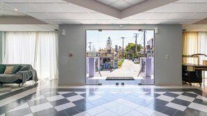 Un vestíbulo de hotel con piso a cuadros, un sofá y vistas a la calle.