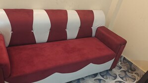 Un sofá rojo y blanco con un diseño de olas en el asiento y el respaldo, sobre un piso estampado.
