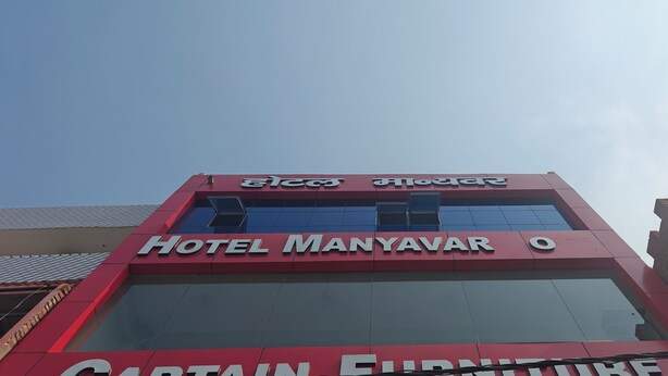 Un edificio con un letrero que dice 'Hotel Manyavar O' y 'Captain Furniture'.
