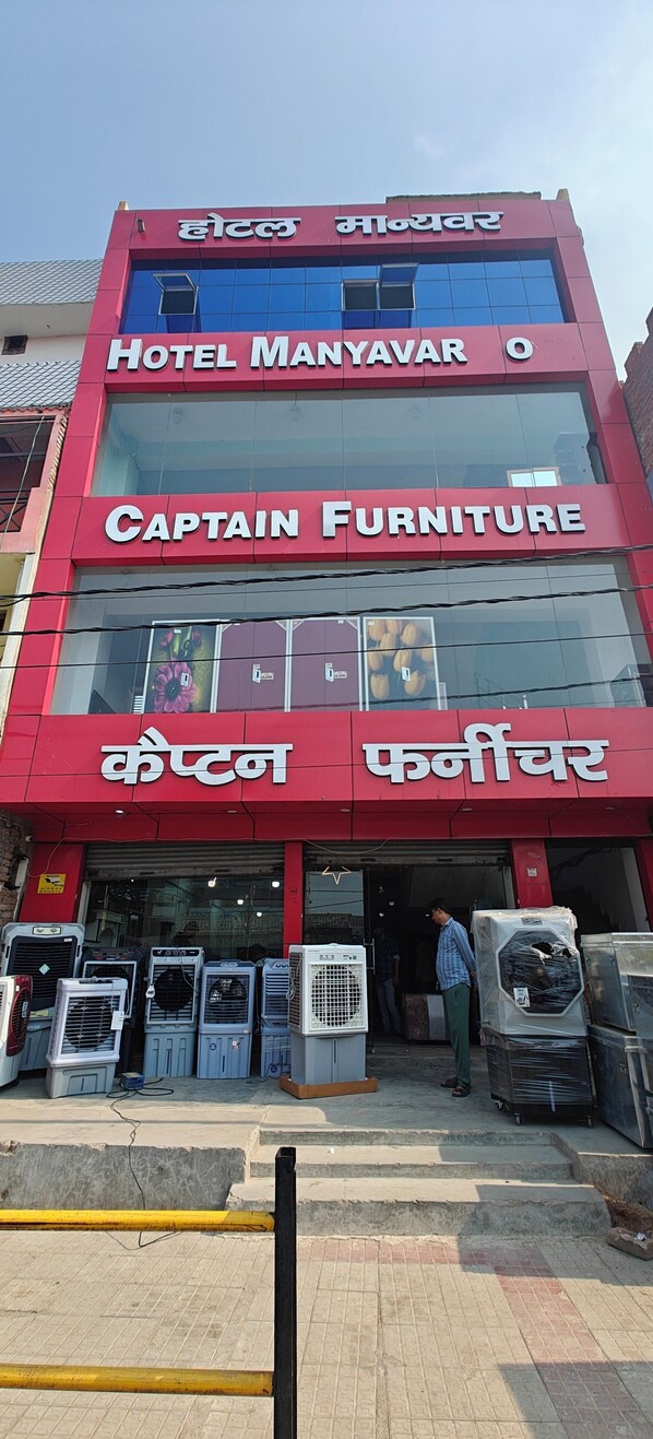 A multi-story building with signage for 'Hotel Manyavar' and 'Captain Furniture.'