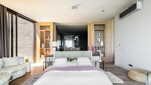 Ein modernes Schlafzimmer mit einem großen Bett, einer Couch und einer eingebauten Bücherwand.