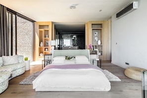 A modern bedroom with a large bed, a sofa, and a built-in bookshelf. - Obsidian (Cape Town)