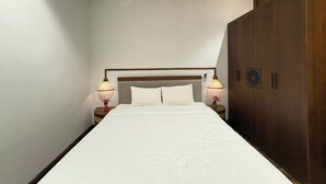A bedroom with a bed, nightstands, lamps, and a wardrobe. - Satori1 Apartment (Hanoi)