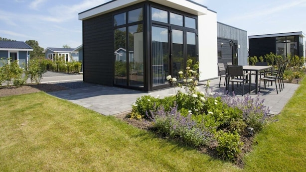 A modern house with a patio, large windows, and a garden. - Holiday Home in Nijkerk With Terrace (Nijkerk)