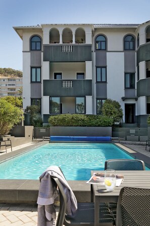 Ein modernes Gebäude mit Schwimmbad, Außenbereich und Balkon.