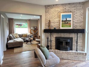 Un salon avec une cheminée, un canapé, une table basse et un tapis.