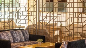 Un interior moderno con un sofá modular, una mesita redonda y un separador decorativo.