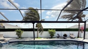 Ein Hallenbad mit klarem, blauem Wasser, umgeben von gefliestem Boden und einer Glaskonstruktion.