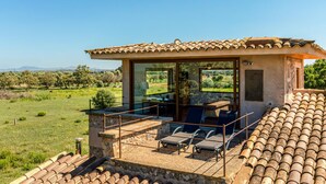 Eine Villa mit Terrasse, Sitzgelegenheiten im Freien und Blick auf die Landschaft.