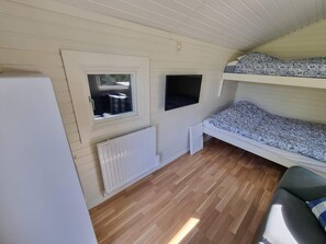 A compact room with a bunk bed, a window with a view, a radiator, and a small seating area. - 3 Person Holiday Home in Onsala (Gottskar)