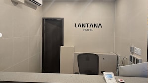 A hotel reception area with a counter, a digital scale, and a wall-mounted sign that reads 'LANTANA HOTEL'. - Hotel Lantana (Changwon)