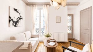 Een moderne woonkamer met een bank, een salontafel, een stoel en een schilderij aan de muur.