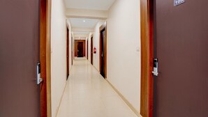 A hotel hallway with doors numbered 101 and 108, a fire alarm, and a lighted ceiling.