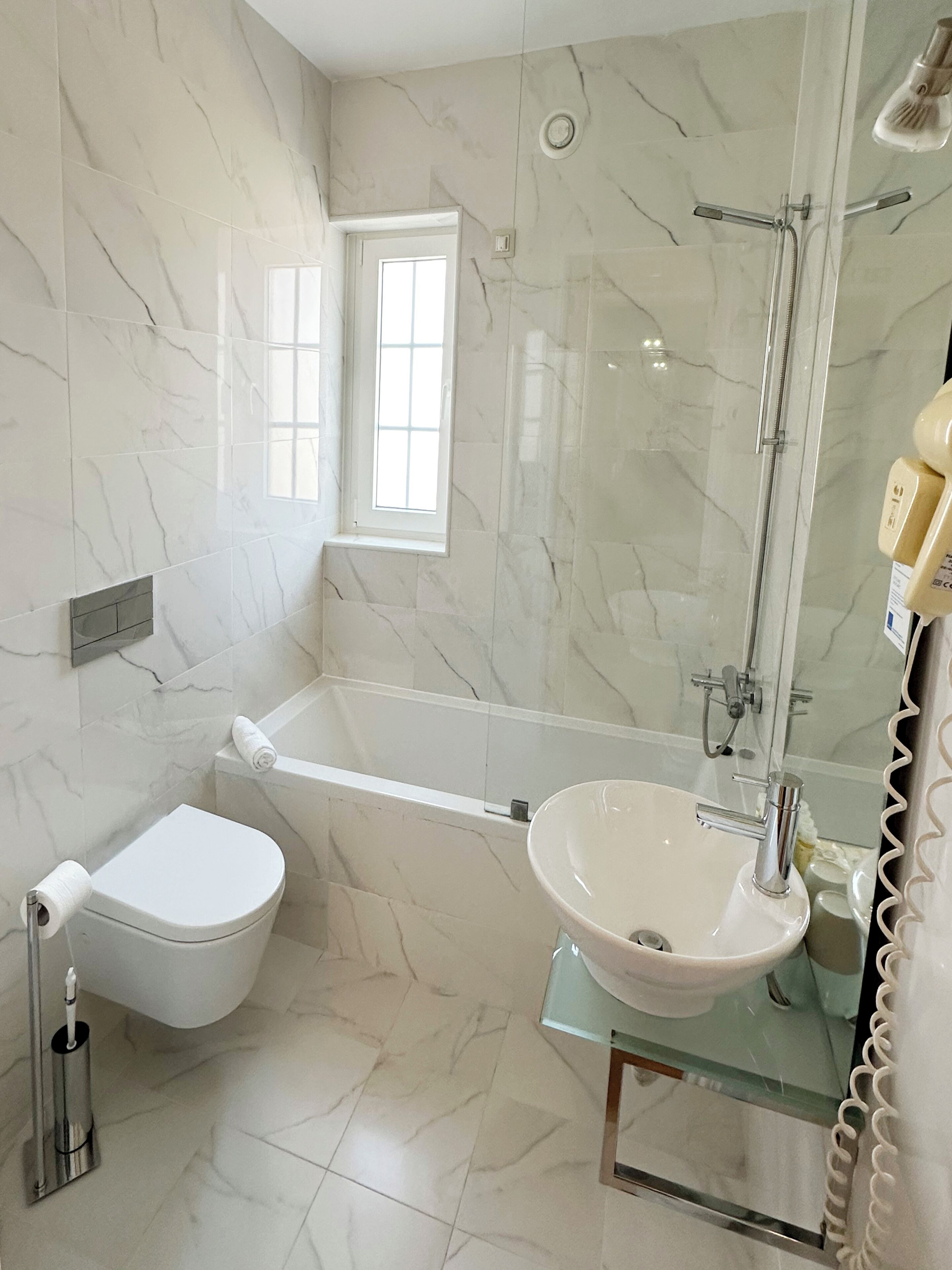 Un baño con inodoro, bañera y lavamanos.
