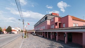 Un edificio rosa con un letrero que dice 'HOTEL' y una calle empedrada al frente.