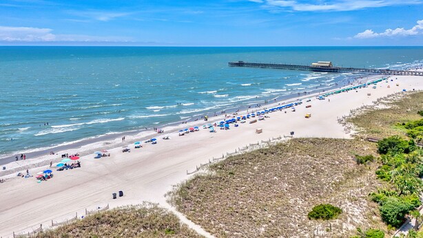 A beach with a pier extending into the water, sandy beach, and a path leading to the beach. - Kingston Plantation-Sleeps 6-2bed/2bath-Full Kitchen-Laundry-Lake View (Myrtle Beach)