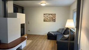 A modern living room with a sofa, a lamp, and a wall-mounted picture.