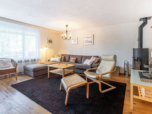 Una sala de estar moderna con un sofá, sillones, una mesa de centro y una chimenea.