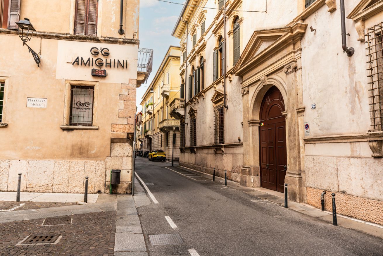 A street with a building labeled 'GG AMIGHINI' and a closed yellow taxi.