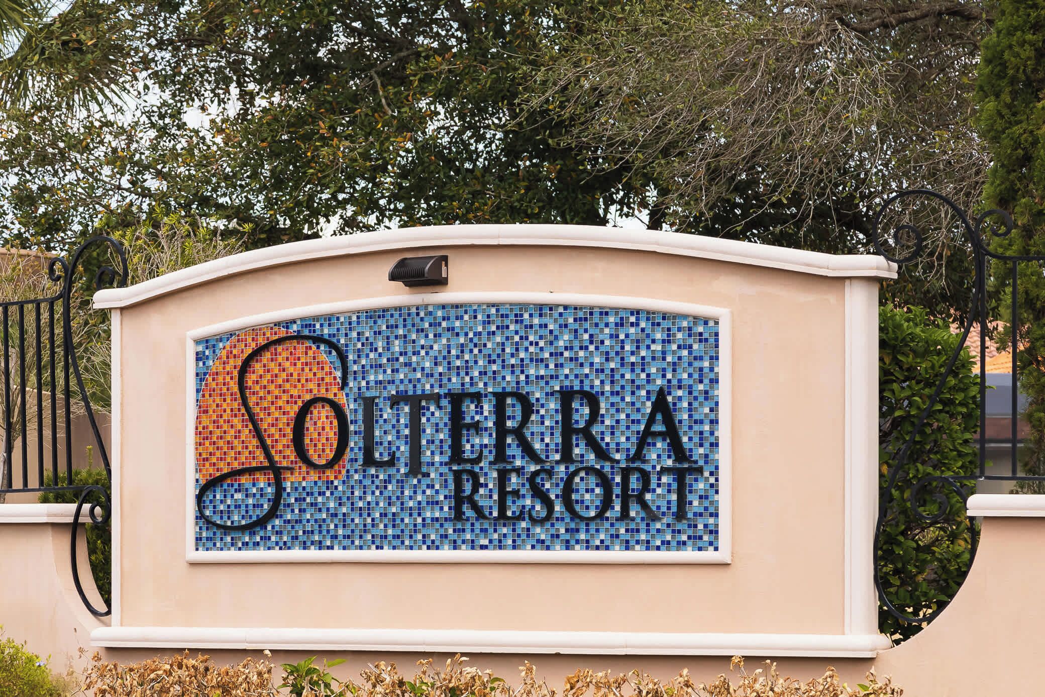 Une enseigne pour le complexe Solterra Resort, avec un motif en mosaïque et un contour noir du nom du complexe.