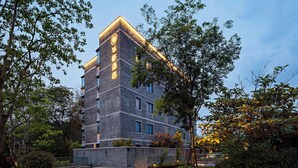 A multi-story hotel with a brick facade and illuminated signage. - Sail Hotel (Chongqing)