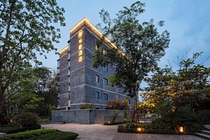 A multi-story hotel with a brick facade and illuminated signage. - Sail Hotel (Chongqing)