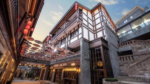 A traditional building with a sign reading 'Sail Hotel,' featuring a balcony, large windows, and a staircase. - Sail Hotel (Chongqing)