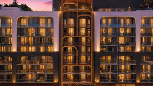 Un hôtel à plusieurs étages doté de balcons, de grandes fenêtres et d’un atrium central.