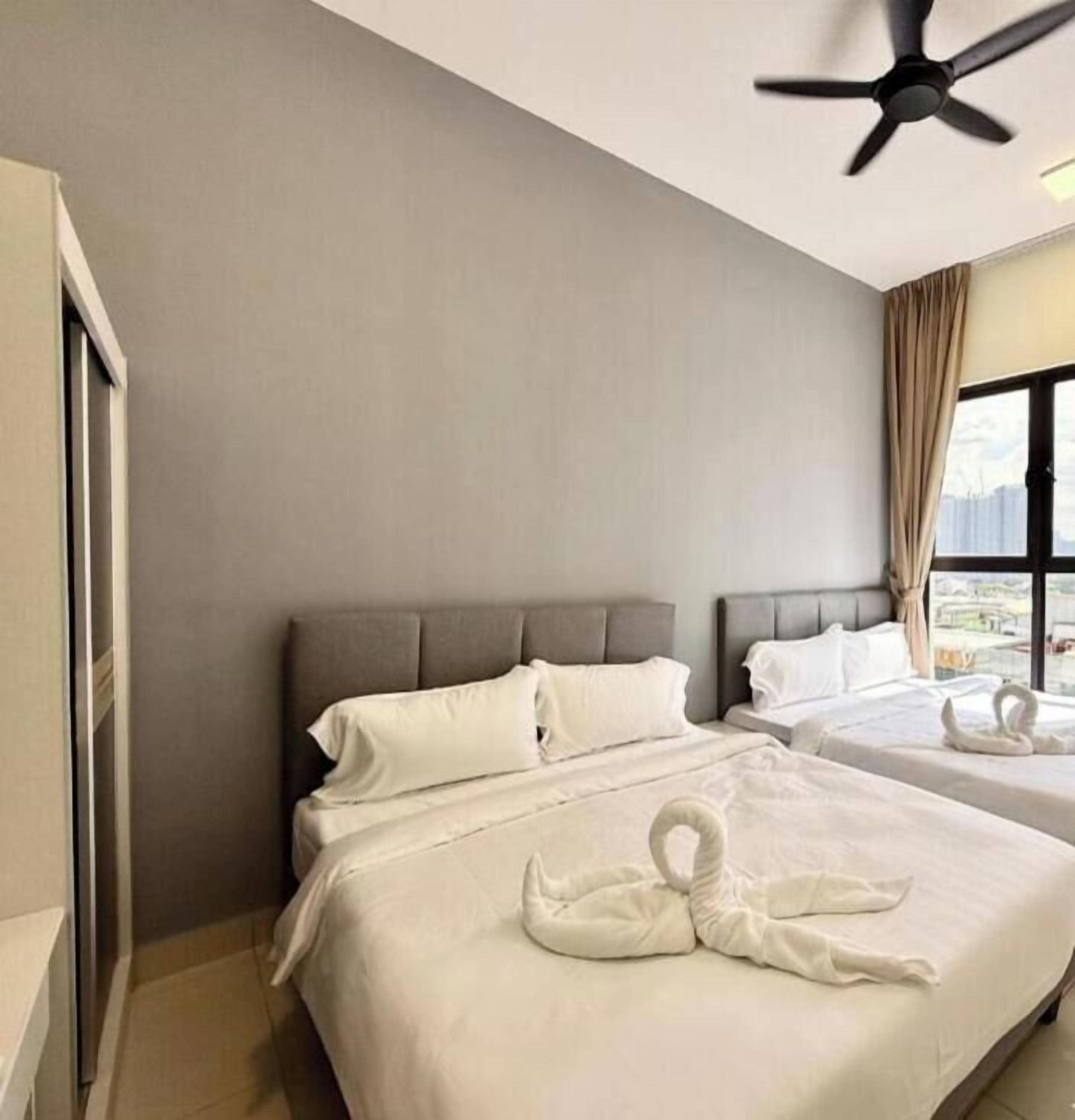 A hotel room with two beds, a ceiling fan, and a view of the city.