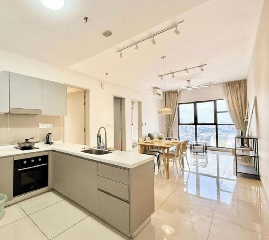 A modern kitchen with a central island, a dining area with a table and chairs, and a large window offering a city view.