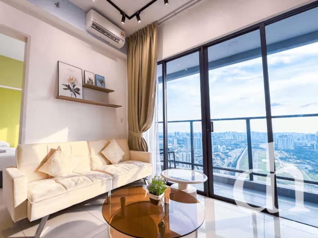 A modern living room with a sofa, a coffee table, and a large window with a city view.