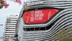 A modern stadium with a prominent red advertisement for basketball games.
